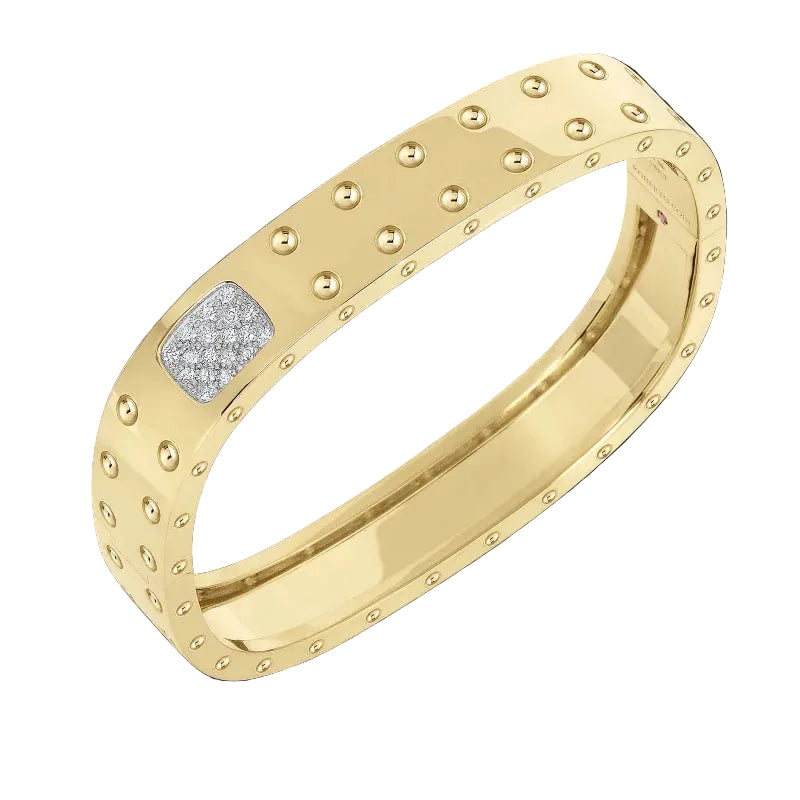 A yellow gold band ring with a textured, beaded outer edge and a square inset set with small clear stones, shown on a solid black background.